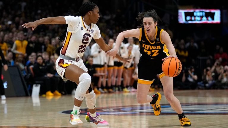 Iowa guard Caitlin Clark (22) drives past South Carolina guard Bree Hall (23) during the first half of the Final Four college basketball championship game in the women's NCAA Tournament, Sunday, April 7, 2024, in Cleveland. (AP Photo/Carolyn Kaster)