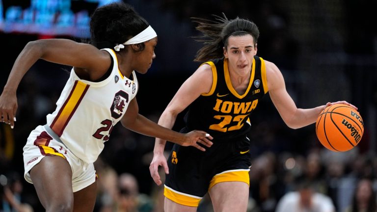 Iowa guard Caitlin Clark (22) drives up court past South Carolina guard Raven Johnson, left, during the first half of the Final Four college basketball championship game in the women's NCAA Tournament, Sunday, April 7, 2024, in Cleveland. (AP Photo/Carolyn Kaster)