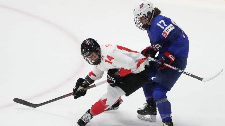 Canada's Renata Fast (14) and United States' Britta Curl (17) battle for the puck during first period hockey action at the IIHF Women's World Hockey Championship in Utica, N.Y., Monday, April 8, 2024. THE CANADIAN PRESS/Christinne Muschi