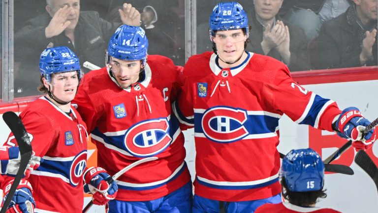 Montreal Canadiens' Nick Suzuki (14) celebrates with teammates Cole Caufield (22) and Juraj Slafkovsky (20) after scoring against the Florida Panthers during second period NHL hockey action in Montreal, Tuesday, April 2, 2024. (Graham Hughes/CP)