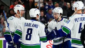 Vancouver Canucks defenceman Quinn Hughes celebrates his goal against the Arizona Coyotes with centre J.T. Miller right wing Conor Garland and centre Elias Pettersson during the second period of an NHL hockey game Wednesday, April 3, 2024, in Tempe, Ariz. (Ross D. Franklin/AP)