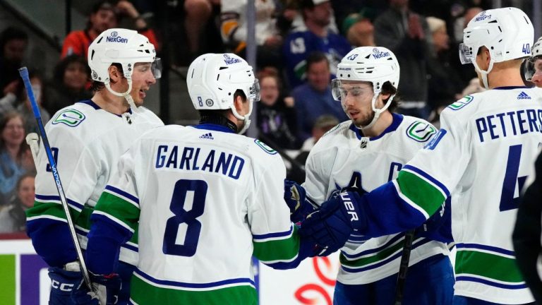 Vancouver Canucks defenceman Quinn Hughes celebrates his goal against the Arizona Coyotes with centre J.T. Miller right wing Conor Garland and centre Elias Pettersson during the second period of an NHL hockey game Wednesday, April 3, 2024, in Tempe, Ariz. (Ross D. Franklin/AP Photo)