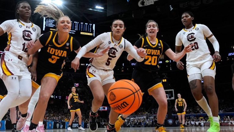 South Carolina guard Tessa Johnson (5) fights for a loose ball with Iowa guard Sydney Affolter (3) and guard Kate Martin (20) during the second half of the Final Four college basketball championship game in the women's NCAA Tournament, Sunday, April 7, 2024, in Cleveland. (AP Photo/Morry Gash)