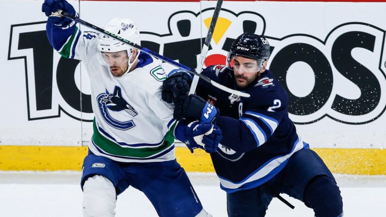 Winnipeg Jets' Dylan DeMelo defends against Vancouver Canucks' Pius Suter during first period NHL action in Winnipeg on Thursday, April 18, 2024. (John Woods/CP Photo)