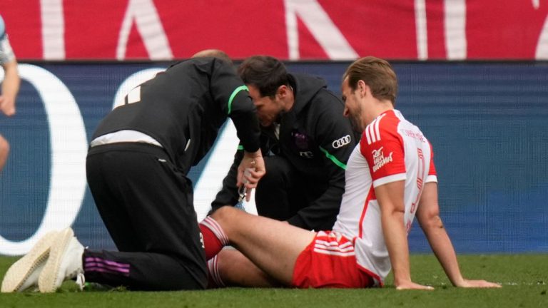 Bayern's Harry Kane is assisted during the German Bundesliga soccer match between Bayern Munich and Eintracht Frankfurt, at the Allianz Arena in Munich, Germany, Saturday, April 27, 2024. (Matthias Schrader/AP Photo)