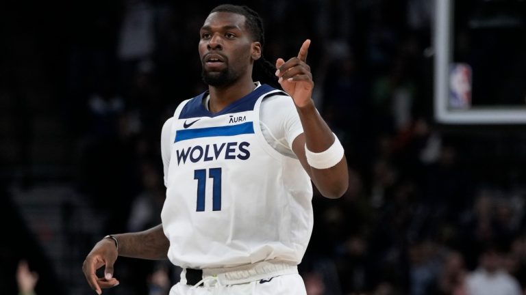 Minnesota Timberwolves center Naz Reid (11) points after making a three-point basket during the first half of an NBA basketball game against the Boston Celtics, Monday, Nov. 6, 2023, in Minneapolis. (AP Photo/Abbie Parr)