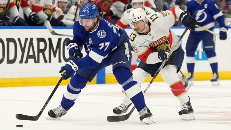 Tampa Bay Lightning defenseman Victor Hedman (77) beats Florida Panthers center Sam Reinhart (13) to a loose puck during the first period in Game 3 of an NHL hockey Stanley Cup first-round playoff series, Thursday, April 25, 2024, in Tampa, Fla. (AP Photo/Chris O'Meara)