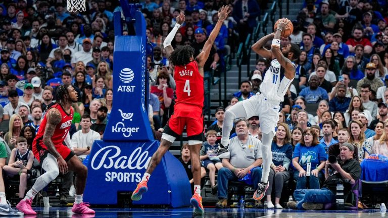 This handout photo provided by the Dallas Mavericks shows Dallas Mavericks guard Kyrie Irving (11) shooting against Houston Rockets defenders Jalen Green (4) and Cam Whitmore (7). (Dallas Mavericks via AP)