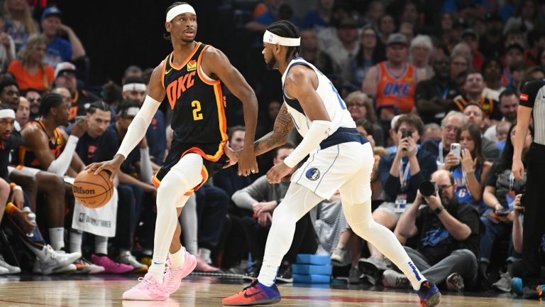 Oklahoma CIty Thunder guard Shai Gilgeous-Alexander, left, looks for an opening past Dallas Mavericks gurd Jaden Hardy, right, in the first half of an NBA basketball game, Sunday, April 14, 2024, in Oklahoma City. (AP Photo/Kyle Phillips)