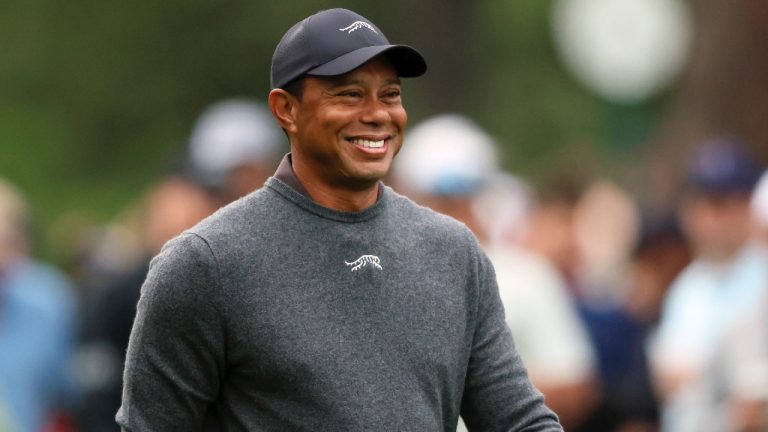 Tiger Woods reacts as he talks with fellow golfers as they walk down the second fairway after their tee shots during a practice round for the Masters golf tournament at Augusta National Golf Club in Augusta, Ga., Tuesday, April 9, 2024. (Jason Getz/Atlanta Journal-Constitution via AP)