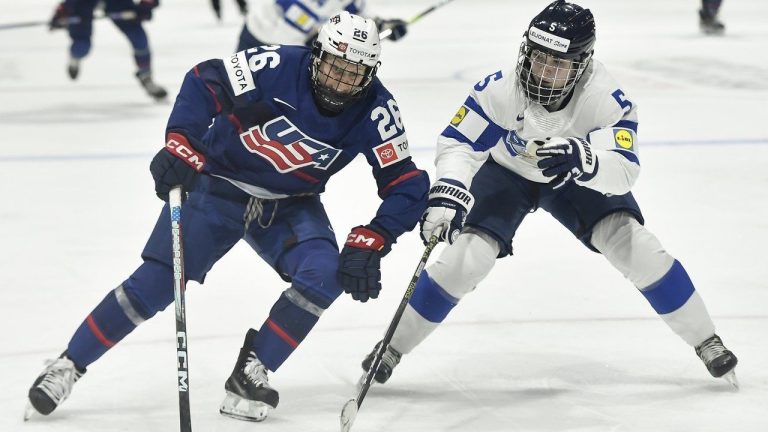 United States forward Kendall Coyne Schofield, left, shields the puck from Finland defensewoman Siiri Yrjola during the second period in the semifinals at the IIHF women's world Hockey Championships in Utica, N.Y., Saturday, April 13, 2024. (Adrian Kraus/AP)