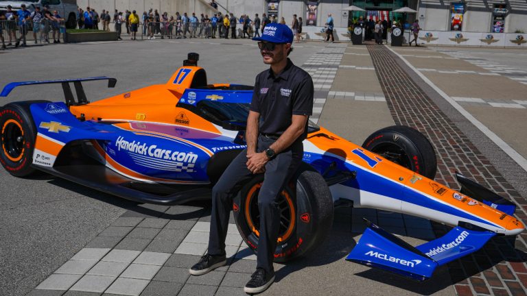 FILE - Kyle Larson sits on the car that he will drive in the IndyCar Indianapolis 500 after is was unveiled at Indianapolis Motor Speedway in Indianapolis, Sunday, Aug. 13, 2023. Larson next month will become the fifth driver in history to attempt to complete “The Double” and run 1,100 miles in one day at both the Indianapolis 500 in an Indy car and the Coca-Cola 600, NASCAR's longest race of the year. (Michael Conroy/AP)