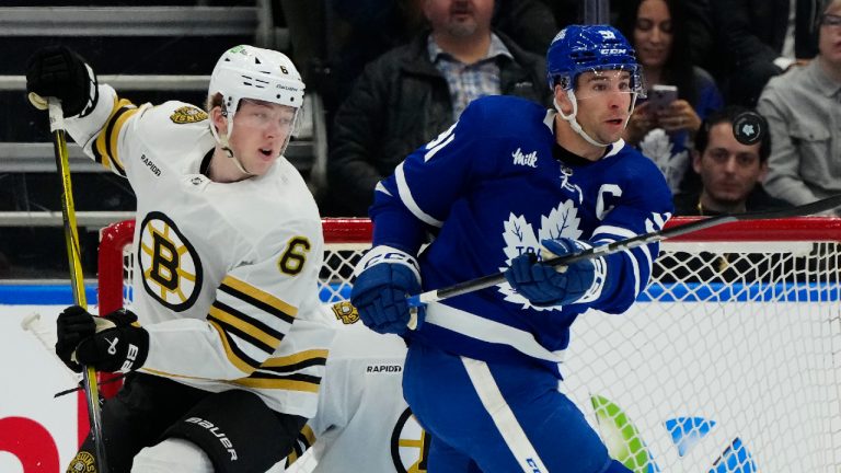 Toronto Maple Leafs centre John Tavares (91) tries to control the puck as Boston Bruins defenceman Mason Lohrei (6) defends during first period NHL hockey action in Toronto on Monday, March 4, 2024. (Frank Gunn/CP)