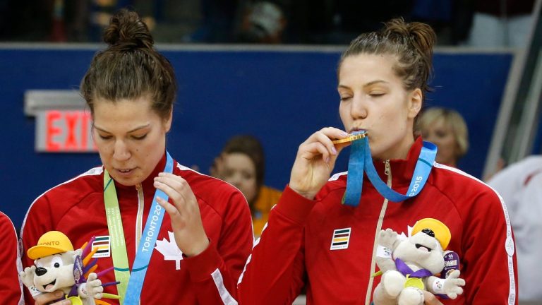 Canada's Michelle Plouffe, right, kisses her gold medal while standing on the podium with her twin sister, Katherine Plouffe, during the women's basketball medal ceremony at the Pan Am Games, Monday, July 20, 2015, in Toronto. (Julio Cortez/AP Photo)