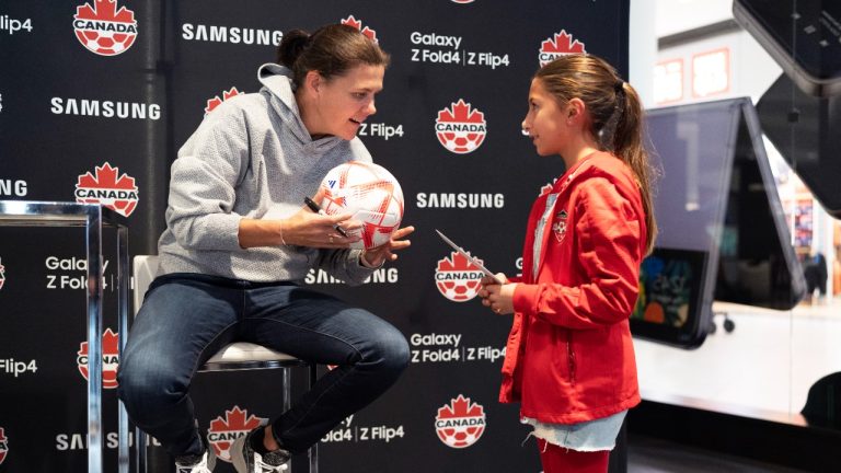 Canadian soccer star Christine Sinclair autographs a fan's ball at a World Cup watch party in Toronto on Wednesday, Nov. 23, 2022. Sinclair is serving as an adviser to Project 8 Sports Inc., a new pro women's soccer league planned to kick off in Canada in 2025. (Arlyn McAdorey/THE CANADIAN PRESS)