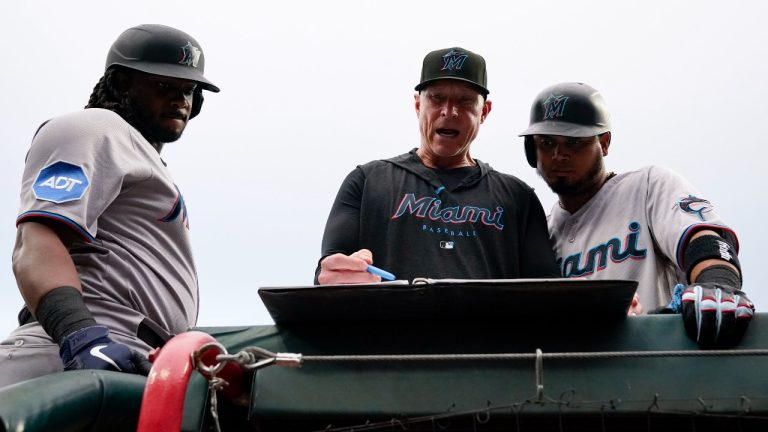 Miami Marlins' Josh Bell, left, and Luis Arraez, right, speak with hitting coach Brant Brown. (Jeff Dean/AP)