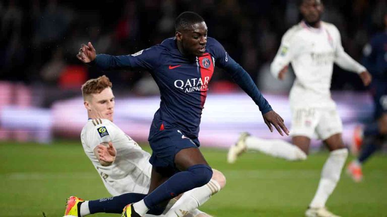 Lyon's Jake O'Brien, left, challenges PSG's Randal Kolo Muani during the French League One soccer match between Paris Saint-Germain and Lyon at the Parc des Princes stadium in Paris, Sunday, April 21, 2024. (Christophe Ena/AP)