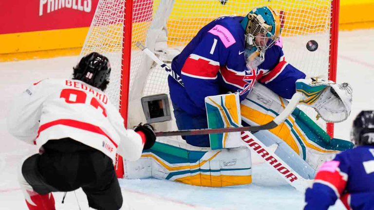 Canada's Connor Bedard, left, shoots to score his sides third goal past Britain's goalkeeper Jackson Whistle during the preliminary round match between Great Britain and Canada at the Ice Hockey World Championships in Prague, Czech Republic, Saturday, May 11, 2024. (Petr David Josek/AP)