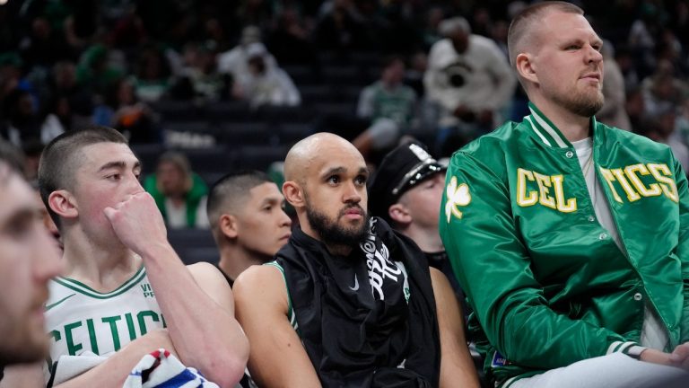 Boston Celtics guard Payton Pritchard, left, guard Derrick White, center, and center Kristaps Porzingis, right, watch from the bench as the Cleveland Cavaliers lead the Celtics during the second half of Game 2 of an NBA basketball second-round playoff series, Thursday, May 9, 2024, in Boston. (Steven Senne/AP)