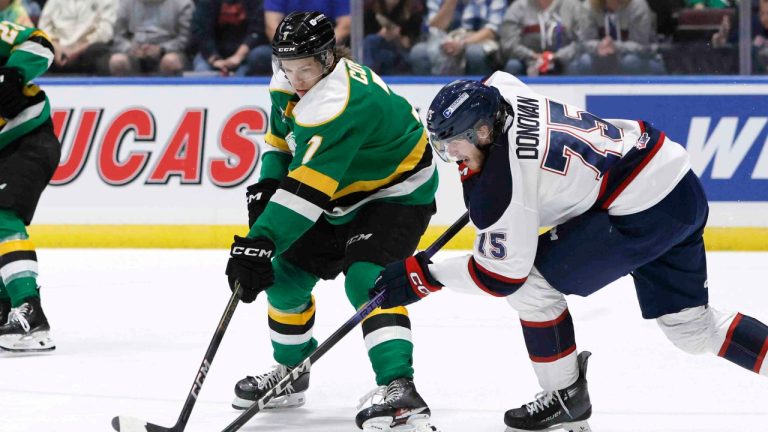 London Knights' Easton Cowan (7) and Saginaw Spirit's Jorian Donovan (75) chase a loose puck during second period Memorial Cup hockey action. (Duane Burleson/CP)