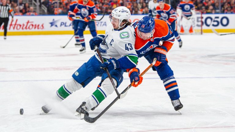 Zach Hyman of the Edmonton Oilers and Quinn Hughes of the Vancouver Canucks battle for the puck. (Paul Swanson/NHLI via Getty Images)