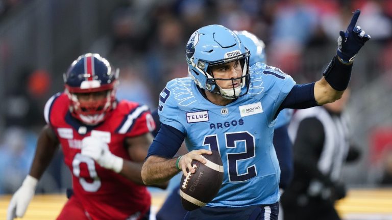 Toronto Argonauts quarterback Chad Kelly (12) runs the ball as Montreal Alouettes defensive end Shawn Lemon (0) looks on during first half CFL Eastern Conference finals football action in Toronto on Saturday, November 11, 2023. (Nathan Denette/THE CANADIAN PRESS)