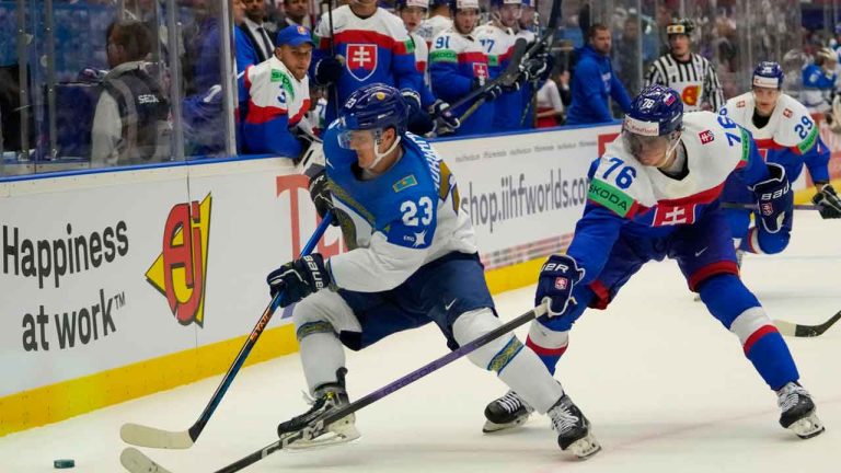 Kazakhstan's Maxim Mukhametov, left, challenges for a puck with Slovakia's Martin Pospisil during the preliminary round match between Slovakia and Kazakhstan at the Ice Hockey World Championships. (Darko Vojinovic/AP)