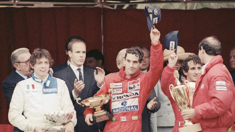 FILE - In this May 7, 1989 file photo, Prince Albert of Monaco, left, applauds Brazil’s Ayrton Senna, centre, winner of the Monaco formula One grand prix ahead of Prost, right, on the podium in Monaco. (Gilbert Tourte/AP)