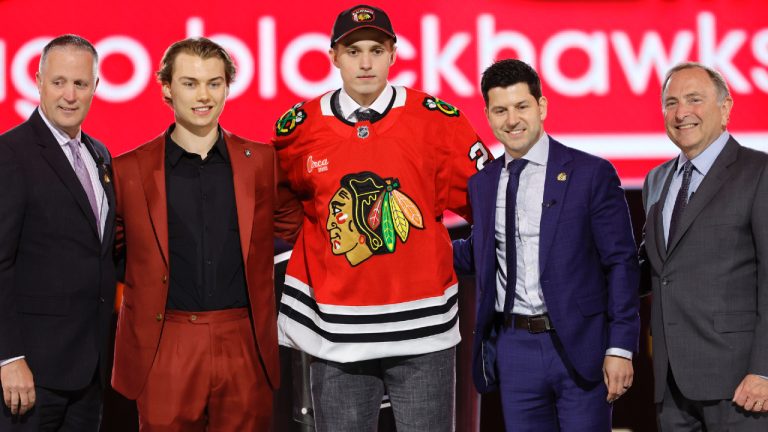 Artyom Levshunov, centre, poses after being selected by the Chicago Blackhawks during the first round of the NHL hockey draft Friday, June 28, 2024, in Las Vegas. (Steve Marcus/AP)