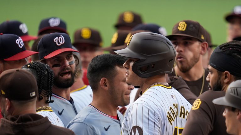 San Diego Padres' Manny Machado, stands with other members of the Padres in front of Washington Nationals following a Jurickson Profar at-bat that turned into a benches clearing altercation, June 25, 2024. (AP Photo/Gregory Bull)