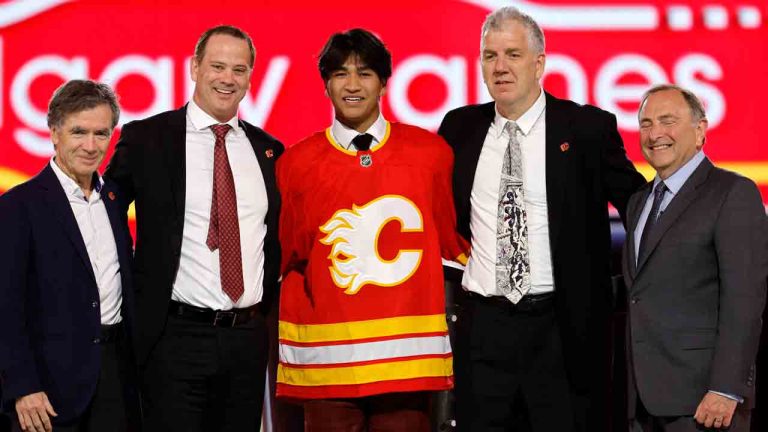 Zayne Parekh, centre, poses after being selected by the Calgary Flames during the first round of the NHL hockey draft Friday, June 28, 2024, in Las Vegas. (Steve Marcus/AP)