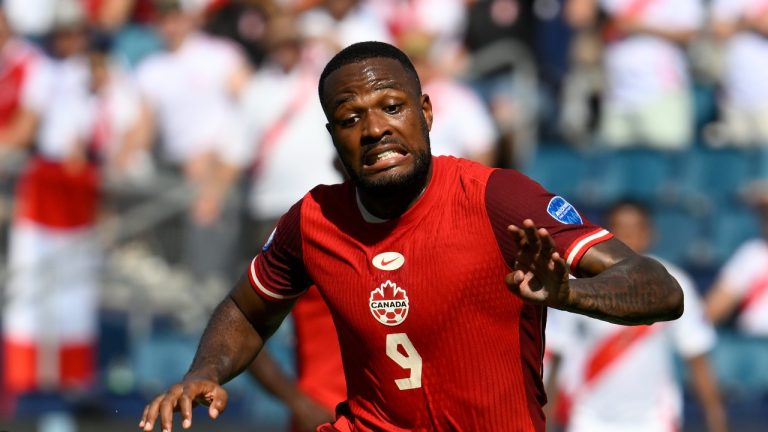 Canada's Cyle Larin chases after a ball after colliding with Peru's Carlos Zambrano during the first half of a Copa America Group A soccer match in Kansas City, Kan., Tuesday, June 25, 2024. (AP Photo/Reed Hoffmann)