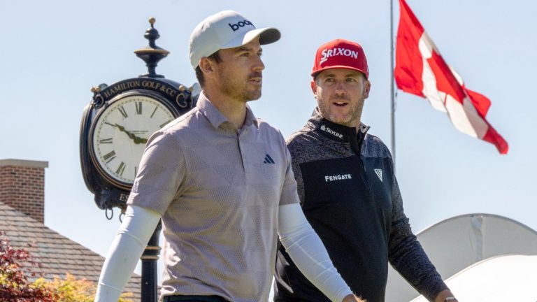 Scotland's Robert MacIntyre, left, low fives his father, Dougie MacIntyre, before posing for photos with the championship trophy after winning the Canadian Open golf tournament in Hamilton, Ontario on Sunday June 2, 2024. THE CANADIAN PRESS/Nathan Denette