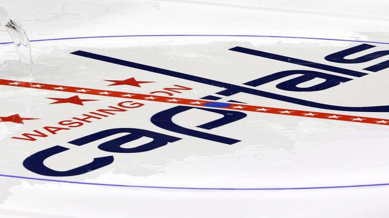 Philip Westmoreland throws water on the Washington Capitals logo at center ice as the logos are placed and the lines painted in preparation for the upcoming NHL hockey season at Verizon Center, Wednesday, Jan. 9, 2013, in Washington. (Alex Brandon/AP)