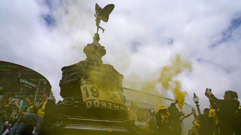 Dortmund supporters light flares as they gather at the Eros statue in Piccadilly Circus in central London ahead of the Champions League final soccer match between Borussia Dortmund and Real Madrid which will take place at Wembley stadium later, Saturday, June 1, 2024. (AP Photo/Alberto Pezzali)