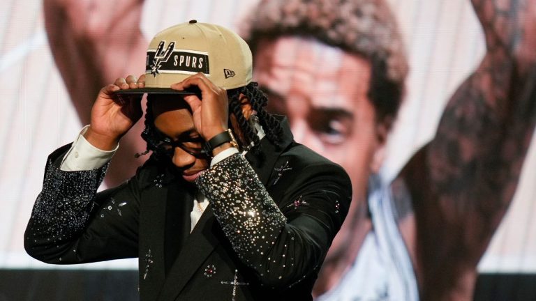 Rob Dillingham, right, dons a San Antonio Spurs hat after being selected by the Spurs during the first round of the NBA basketball draft, Wednesday, June 26, 2024, in New York. (Julia Nikhinson/AP Photo)