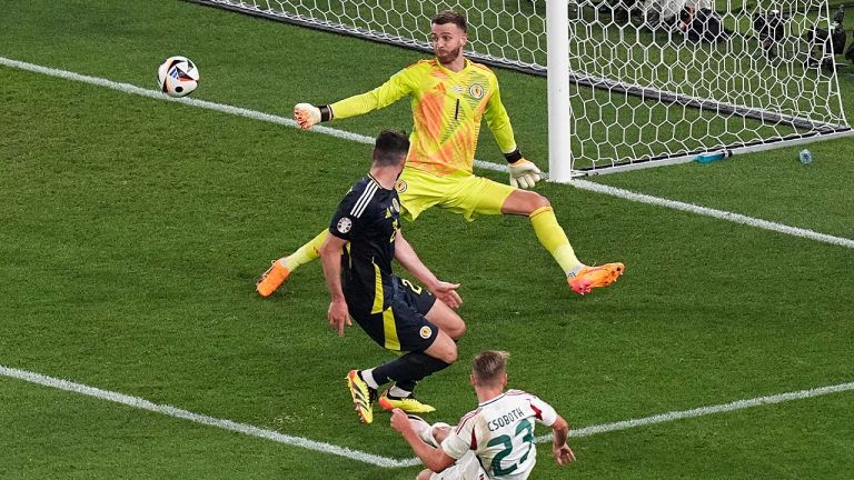 Hungary's Kevin Csoboth, bottom, shoots past Scotland's goalkeeper Angus Gunn, top, during a Group A match between Scotland and Hungary at the Euro 2024 soccer tournament in Stuttgart, Germany, Sunday, June 23, 2024. (Ariel Schalit/AP)