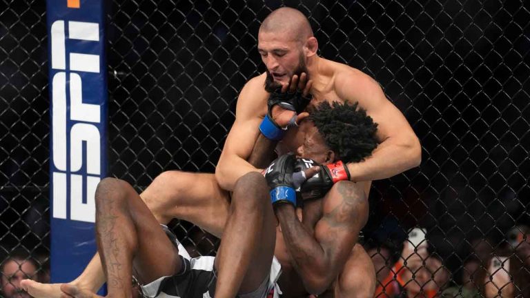 Khamzat Chimaev, top, fights Kevin Holland in a 180-pound catchweight bout during the UFC 279 mixed martial arts event. (John Locher/AP)