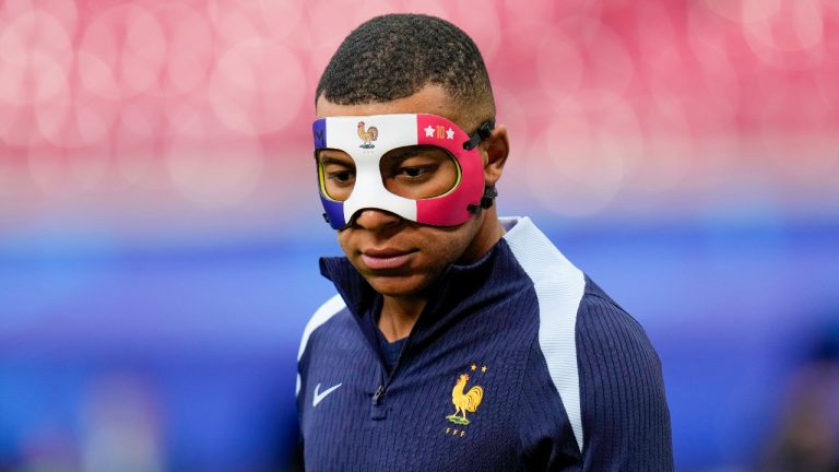 France's Kylian Mbappe wears a face mask as he runs during a training session in Leipzig, Germany. (Hassan Ammar/AP)