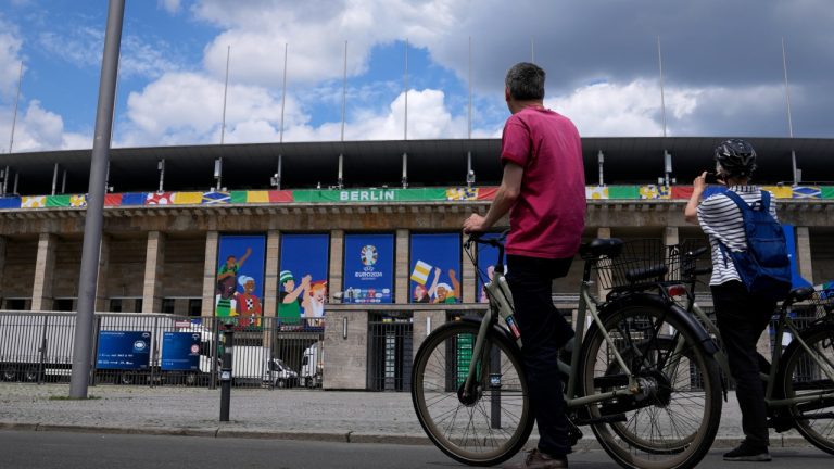 A woman takes a photograph of the Olympic Stadium in Berlin, Germany, Monday, June 10, 2024. (AP Photo/Thanassis Stavrakis)