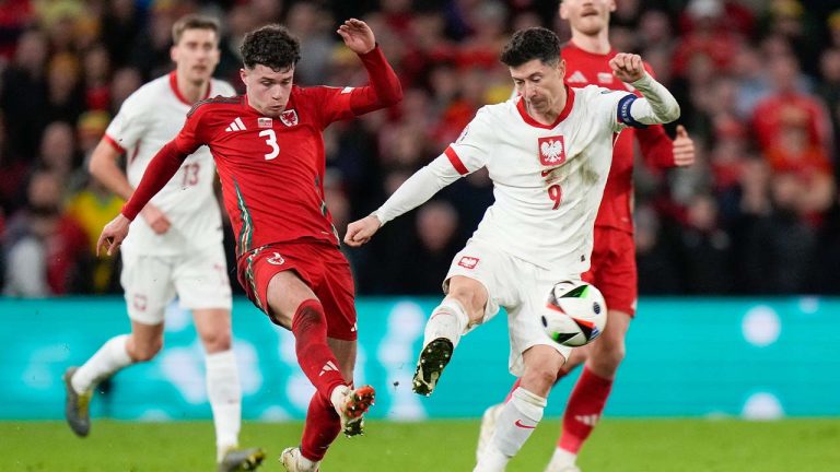 Poland's Robert Lewandowski, right, and Wales Neco Williams compete for the ball during Euro 2024 soccer play-off match between Wales and Poland at Cardiff City Stadium, Wales, Tuesday, March 26, 2024. (Alastair Grant/AP)