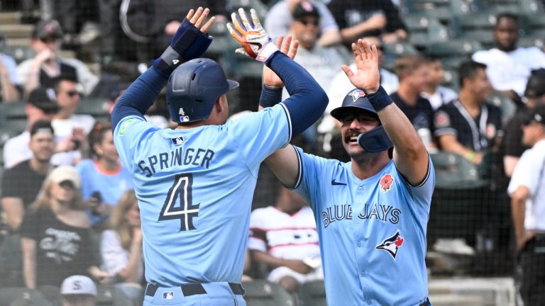 Toronto Blue Jays' Davis Schneider, right, high-fives George Springer (4) after they scored on Schneider's two-run home run against the Chicago White Sox during the ninth inning of a baseball game, Monday, May 27, 2024, in Chicago. (AP Photo/Matt Marton)