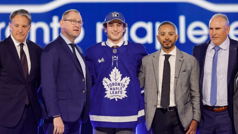 Ben Danford, centre, poses after being selected by the Toronto Maple Leafs during the first round of the NHL hockey draft Friday, June 28, 2024, in Las Vegas. (Steve Marcus/AP)