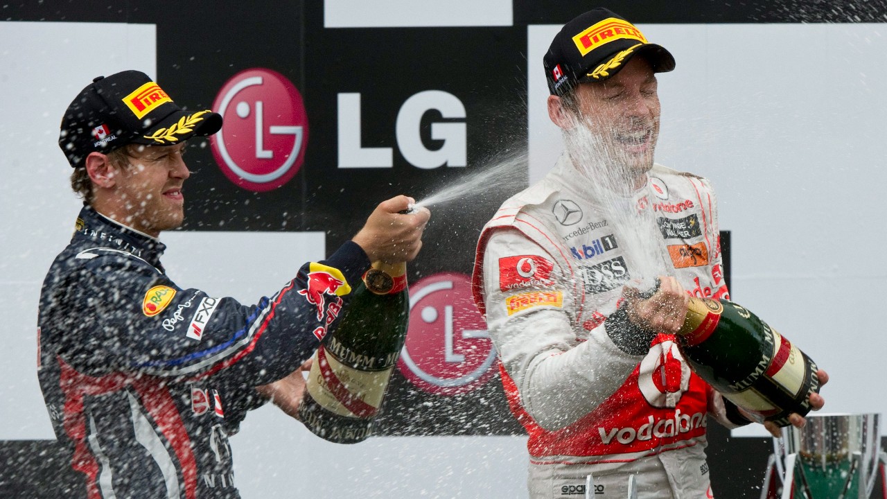 Second place Red Bull driver Sebastian Vettel, of Germany, sprays race winner McLaren Mercedes driver Jenson Button, of Britain during victory ceremonies at the Canadian Grand Prix, Sunday, June 12, 2011 in Montreal. (Paul Chiasson/CP)