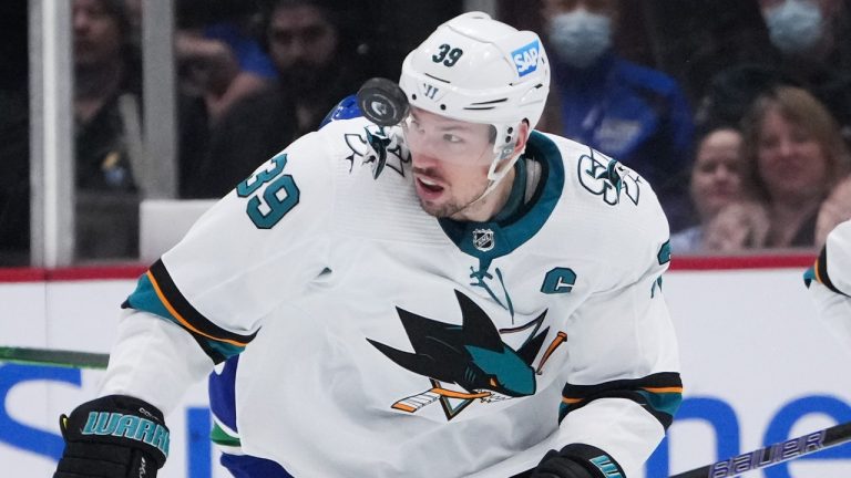 The puck bounces up in front of San Jose Sharks' Logan Couture during the second period of an NHL hockey game against the Vancouver Canucks in Vancouver, on Saturday, April 9, 2022. (Darryl Dyck/CP)