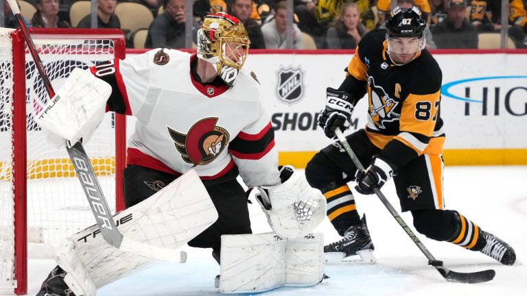 Pittsburgh Penguins' Sidney Crosby (87) takes a pass from Bryan Rust (not shown) and gets a shot behind Ottawa Senators goaltender Joonas Korpisalo (70) for a goal during the second period of an NHL hockey game in Pittsburgh, Saturday, Oct. 28, 2023. (Gene J. Puskar/AP)