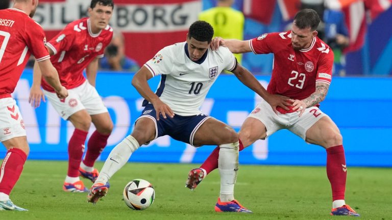 Denmark's Pierre-Emile Hojbjerg, right, challenges England's Jude Bellingham during a Group C match between Denmark and England. (Thanassis Stavrakis/CP)