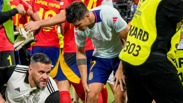 Spain's Alvaro Morata holds his leg after an incident with an invader after a semifinal match between Spain and France at the Euro 2024 tournament, July 9, 2024. (AP Photo/Hassan Ammar)