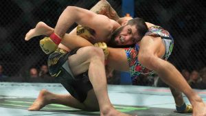 Russia's Islam Makhachev, with red on gloves, works against Dustin Poirier during the first round of a lightweight title bout at the UFC 302 mixed martial arts event Sunday, June 2, 2024, in Newark, N.J. Makhachev won the bout. (Frank Franklin II/AP)