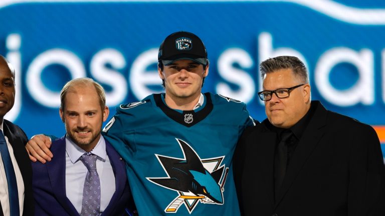 Sam Dickinson, center, poses after being selected by the San Jose Sharks during the first round of the NHL hockey draft Friday, June 28, 2024, in Las Vegas. (Steve Marcus/AP)